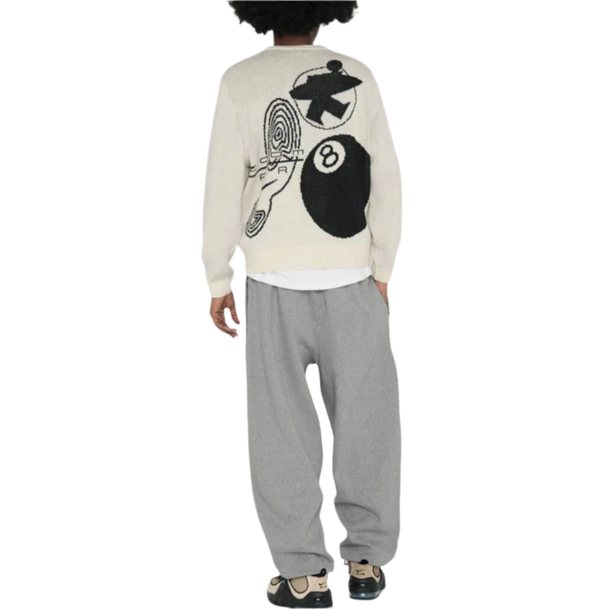 Person wearing a white Stüssy sweater with black and gray designs and gray pants on a white background